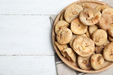 Photo of Tasty dried figs on white wooden table, top view. Space for text