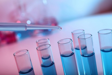 Dripping reagent into test tube with blue liquid, closeup. Laboratory analysis