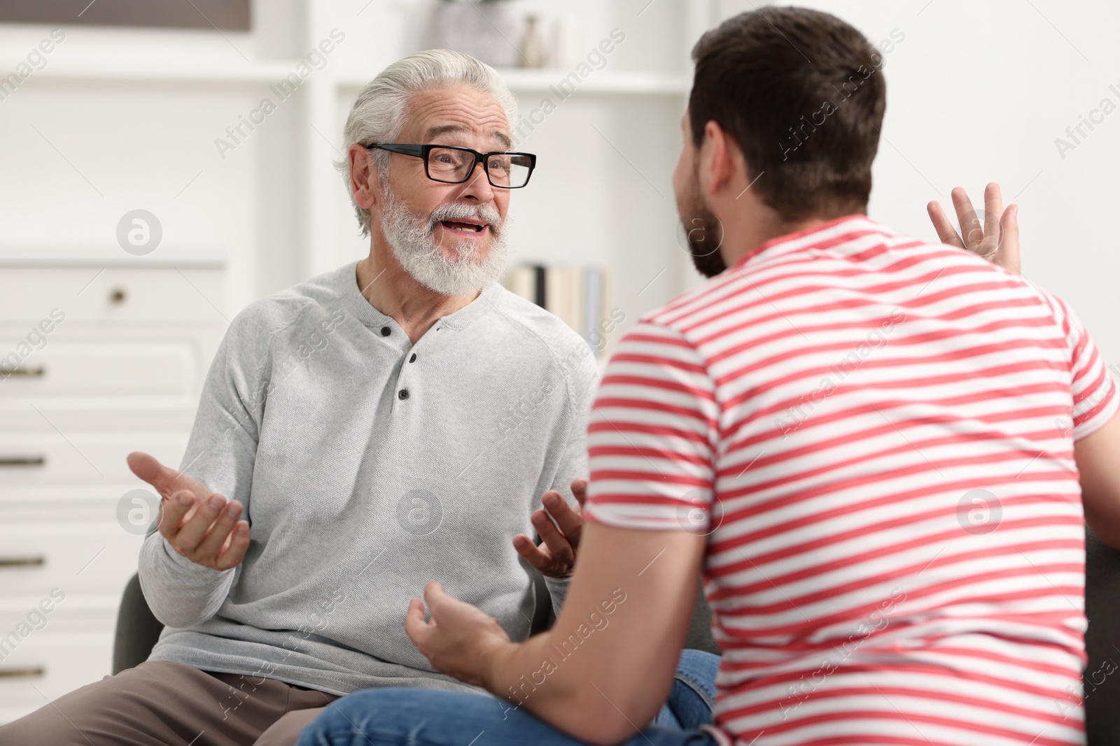 Photo of Happy son and his dad talking at home