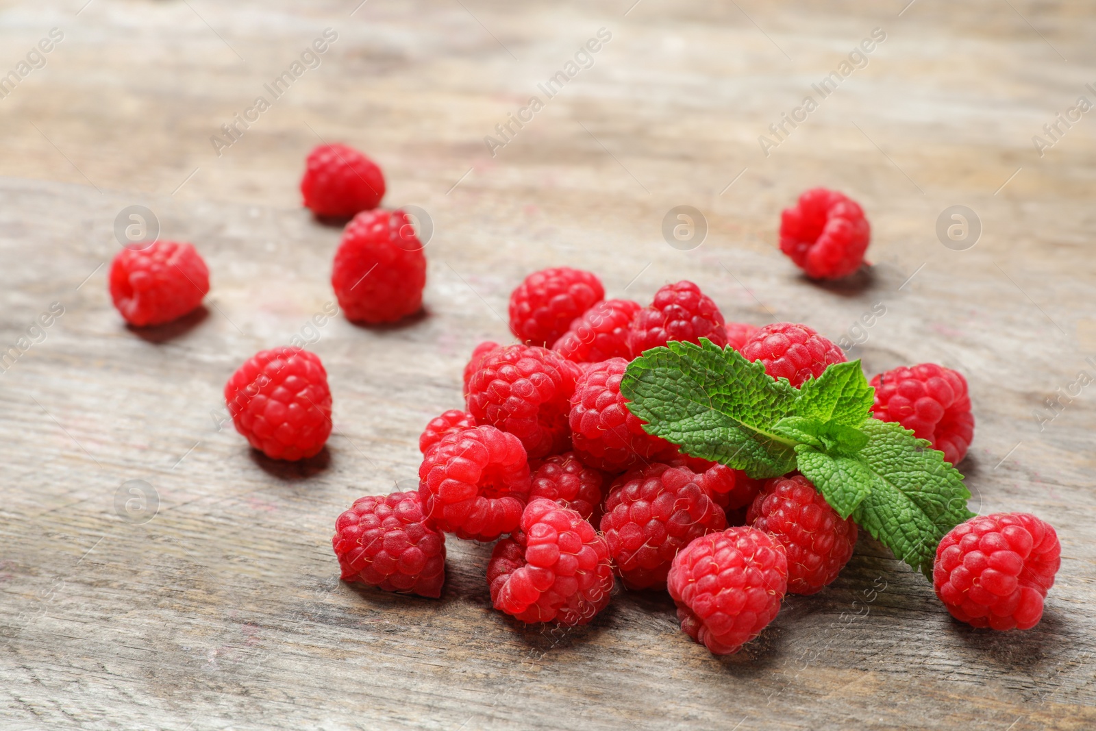 Photo of Ripe aromatic raspberries on wooden table