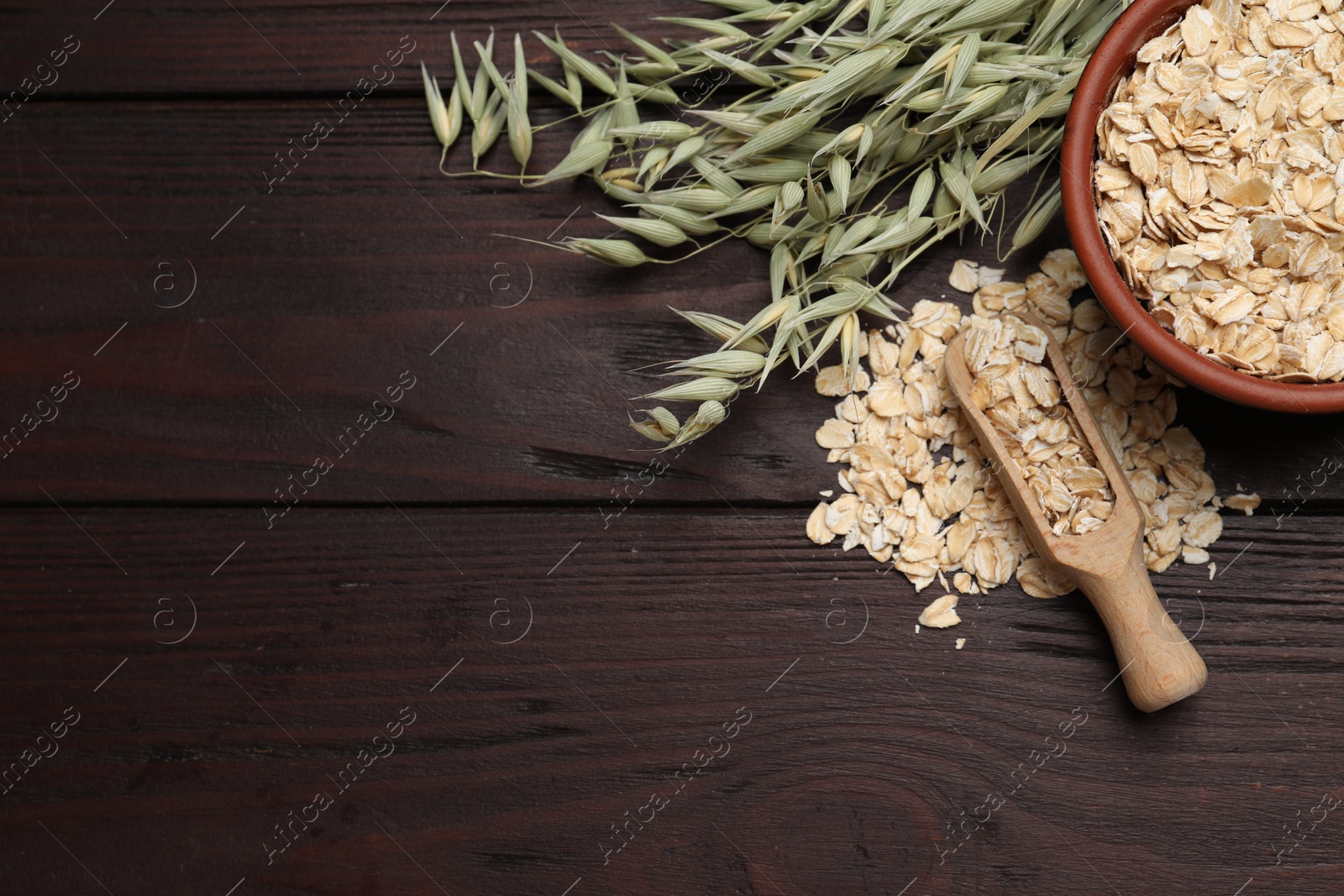 Photo of Oatmeal and branches with florets on wooden table, flat lay. Space for text