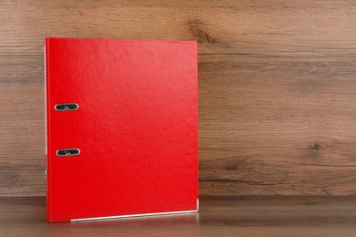 Photo of Red office folder on wooden table, space for text