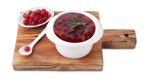 Wooden board with cranberry sauce, fresh berries, spoon and rosemary isolated on white