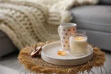 Photo of Cup of drink and burning candles on stand in room, space for text. Interior elements