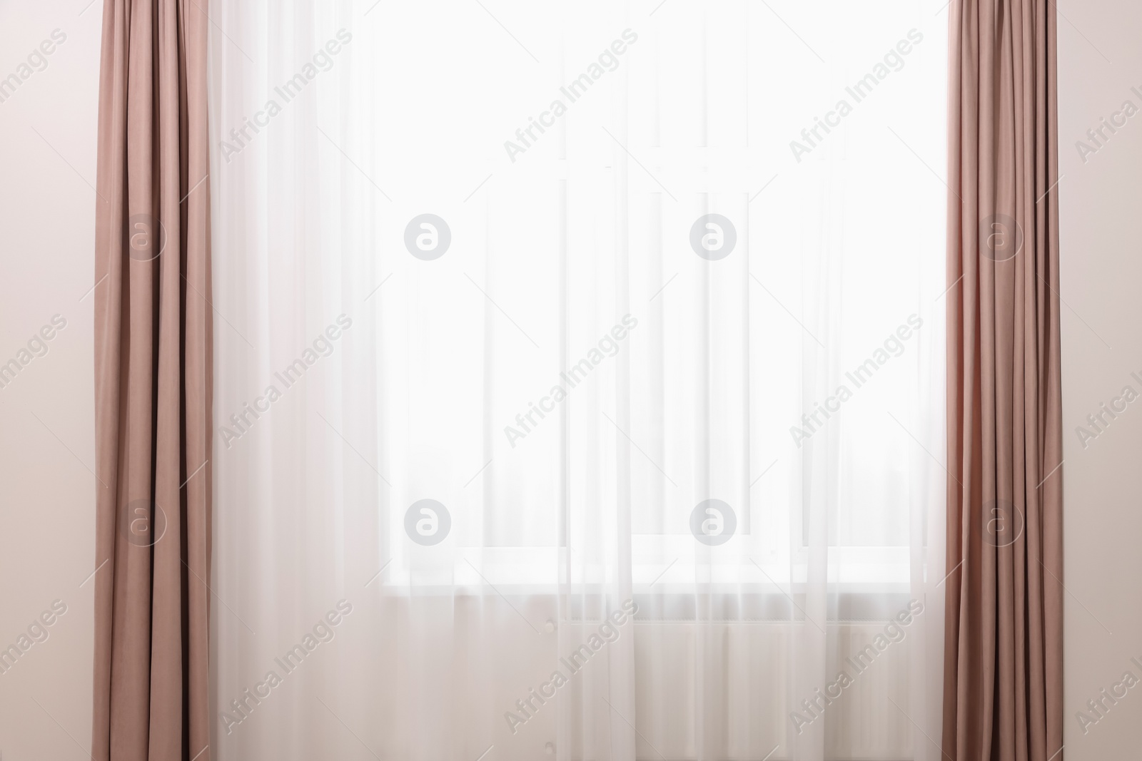 Photo of Elegant window curtains and white tulle indoors. Interior design