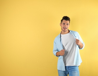 Young man in t-shirt on color background. Mockup for design