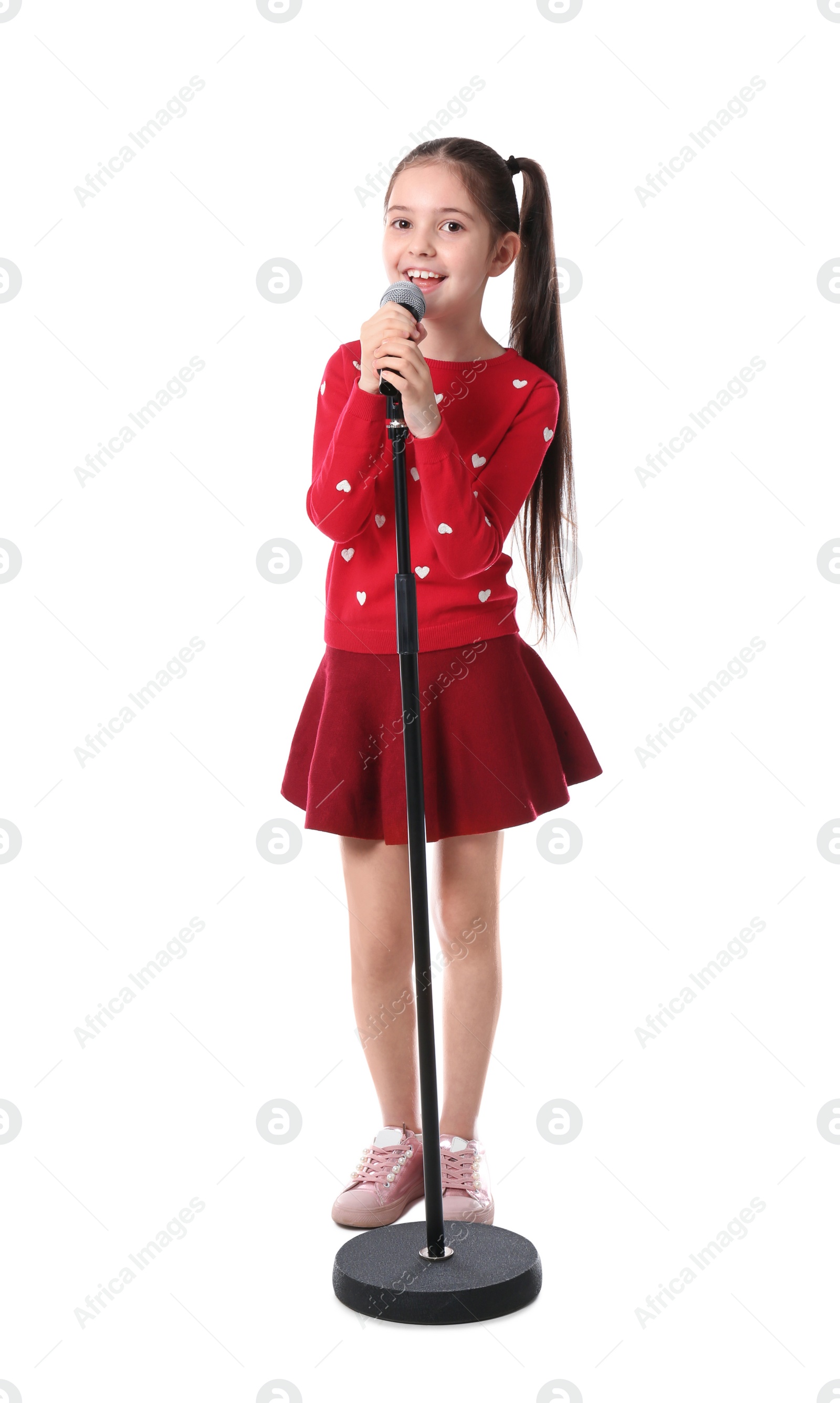 Photo of Little girl singing into microphone on white background