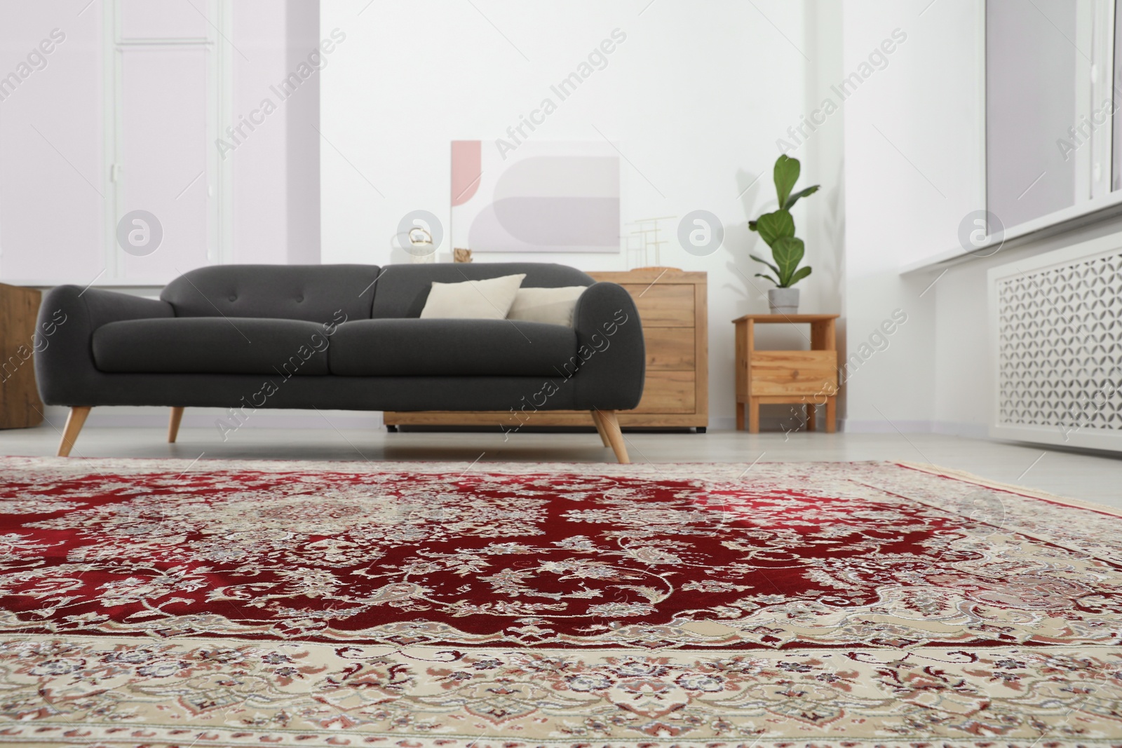 Photo of Cozy room interior with stylish furniture and soft carpet with beautiful pattern