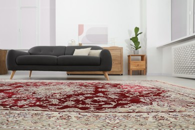 Photo of Cozy room interior with stylish furniture and soft carpet with beautiful pattern