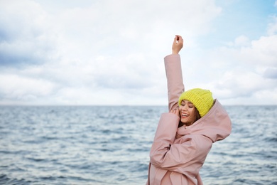 Photo of Stylish young woman spending time near sea