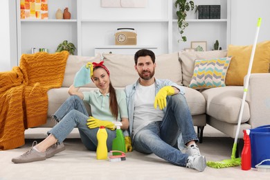 Spring cleaning. Couple with detergents and mop in living room