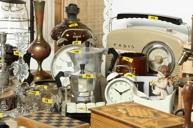 Photo of Many different items on wooden table indoors. Garage sale