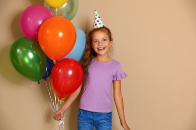 Photo of Happy girl with balloons on brown background. Birthday celebration