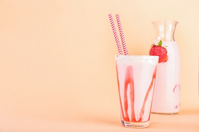Photo of Glassware with delicious milk shakes on color background