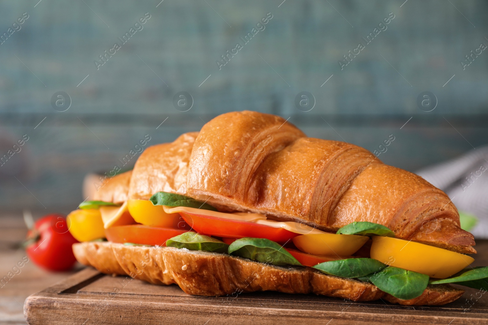 Photo of Tasty vegetarian croissant sandwich on table, closeup