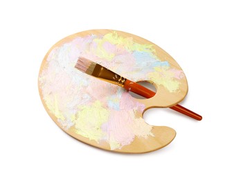 Photo of Wooden artist's palette with mixed pastel paints and brush isolated on white