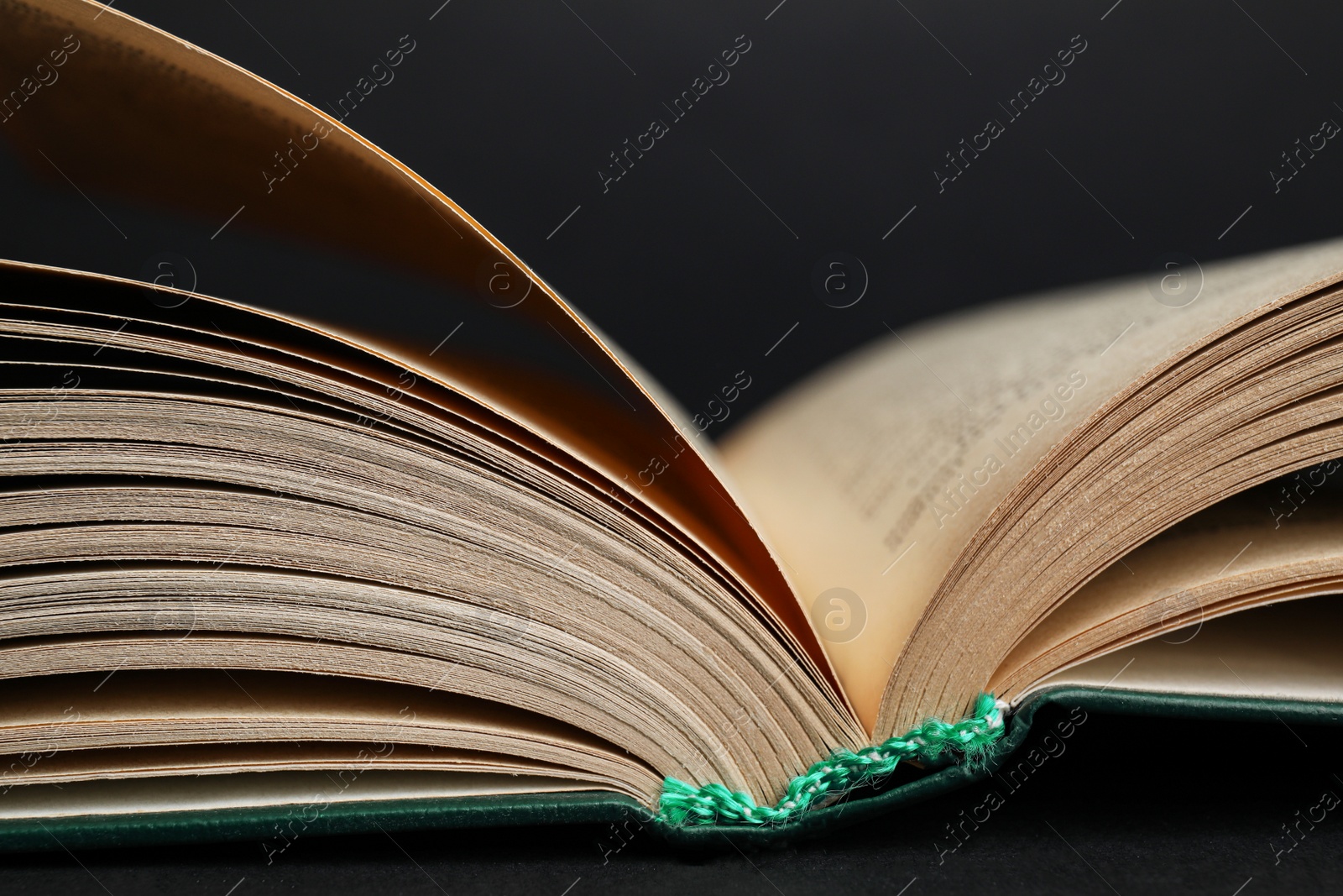 Photo of Closeup view of open book on black background