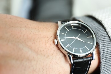 Photo of Businessman wearing luxury wrist watch with leather band, closeup