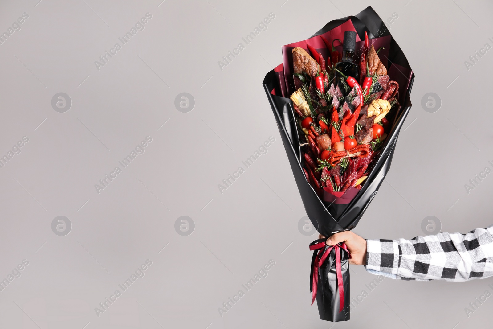 Photo of Man with beautiful food bouquet on light grey background, closeup. Space for text