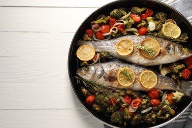 Photo of Baked fish with vegetables, rosemary and lemon on white wooden table, top view. Space for text