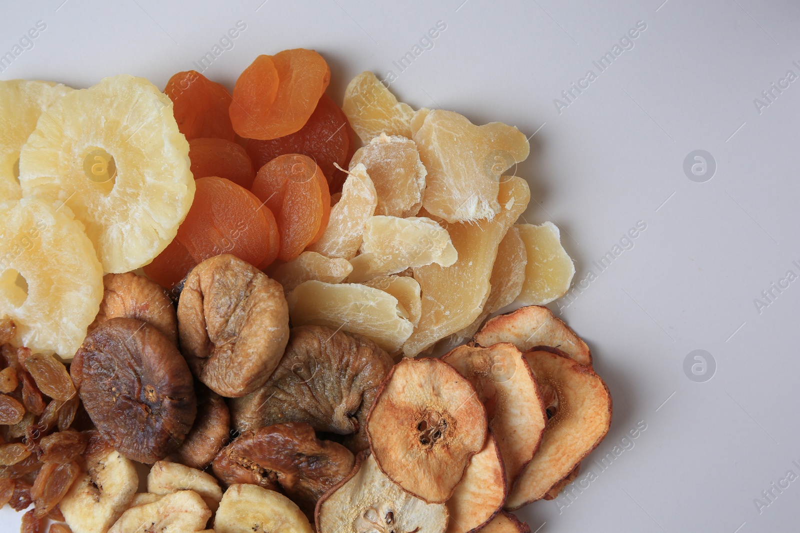 Photo of Pile of different dried fruits on white background, top view