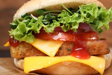 Photo of Delicious burger with tofu, fresh vegetables and sauce on table, closeup