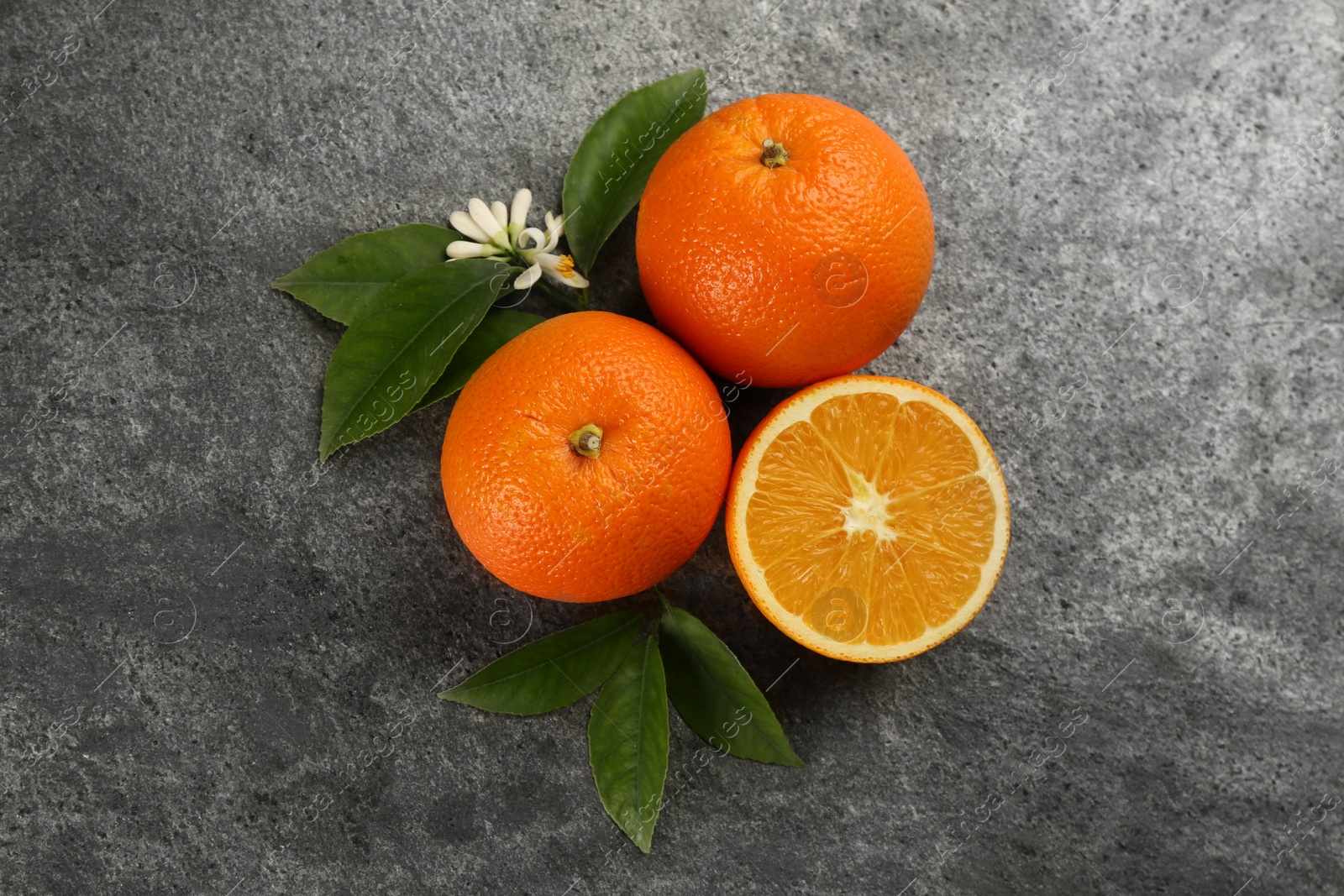 Photo of Delicious ripe oranges on grey table, flat lay