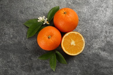 Delicious ripe oranges on grey table, flat lay