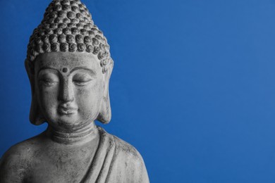 Beautiful stone Buddha sculpture on blue background. Space for text