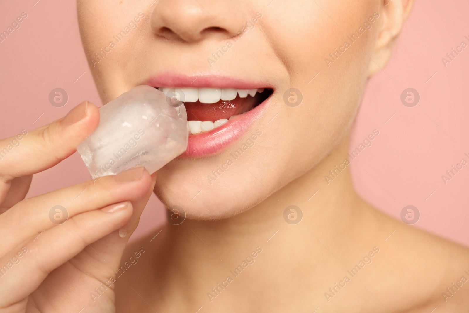 Photo of Young woman with ice cube on color background, closeup