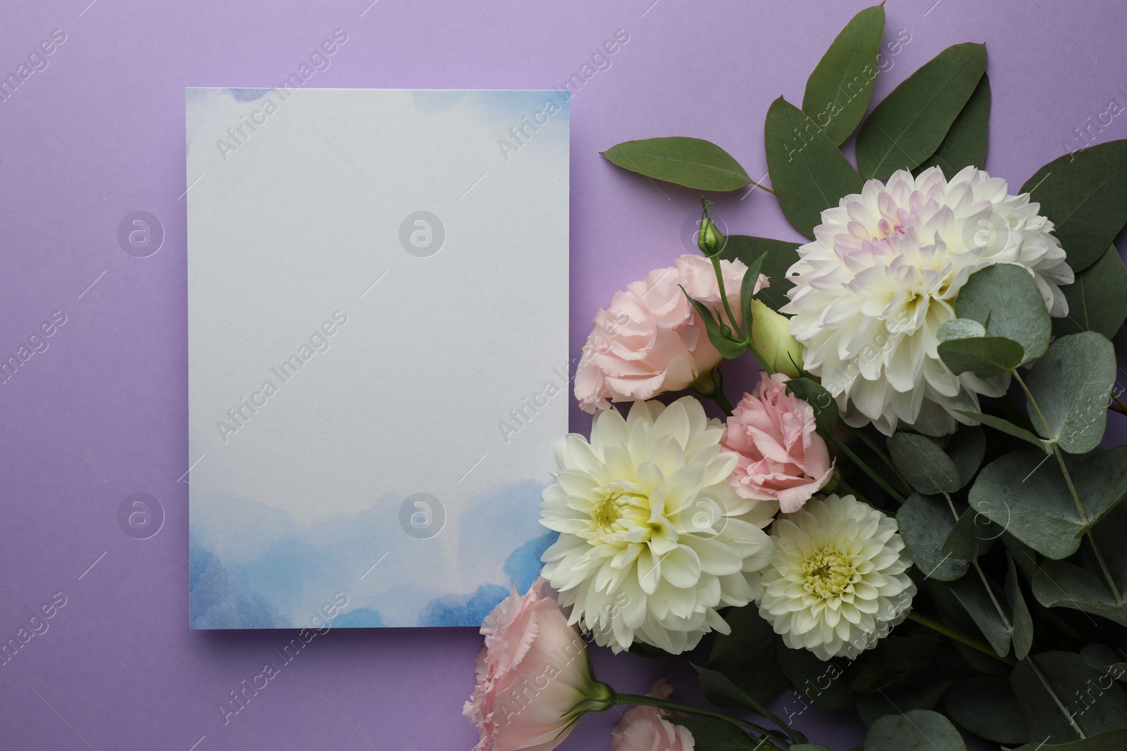 Photo of Blank invitation card and beautiful flowers on violet background, flat lay. Space for text