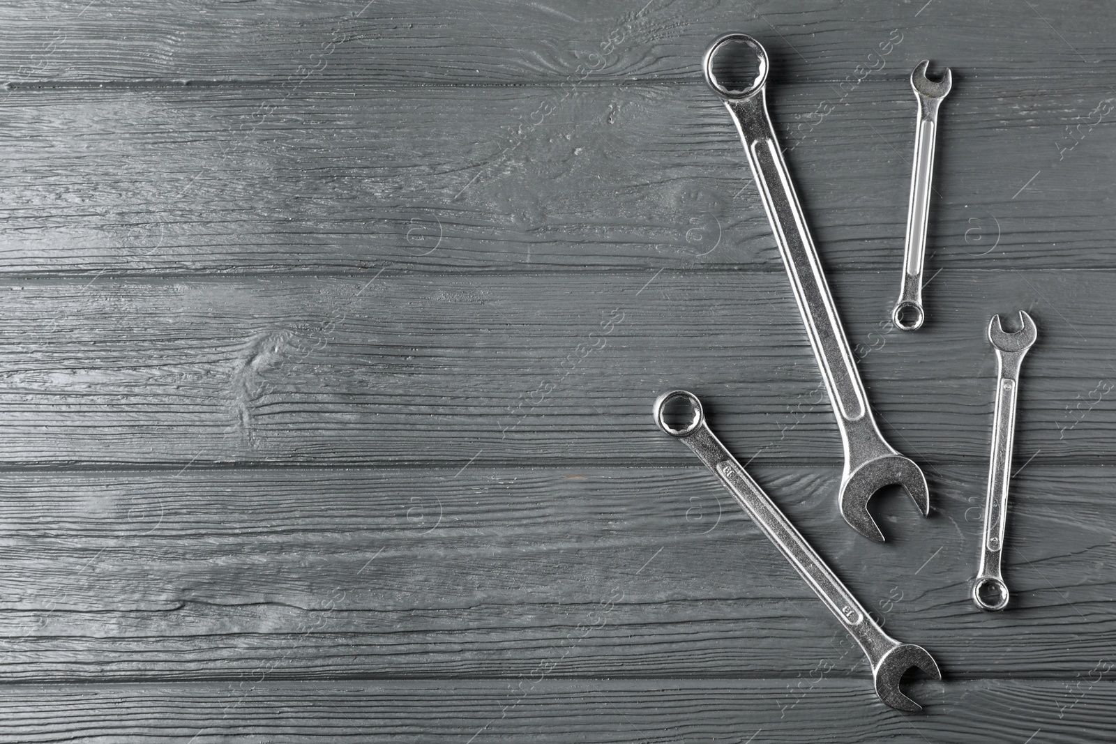 Photo of New wrenches on wooden background, top view with space for text. Plumber tools