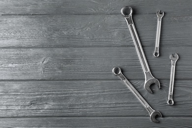 Photo of New wrenches on wooden background, top view with space for text. Plumber tools