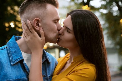 Happy young couple kissing on city street