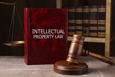 Image of Intellectual Property law book and judge's gavel on grey marble table