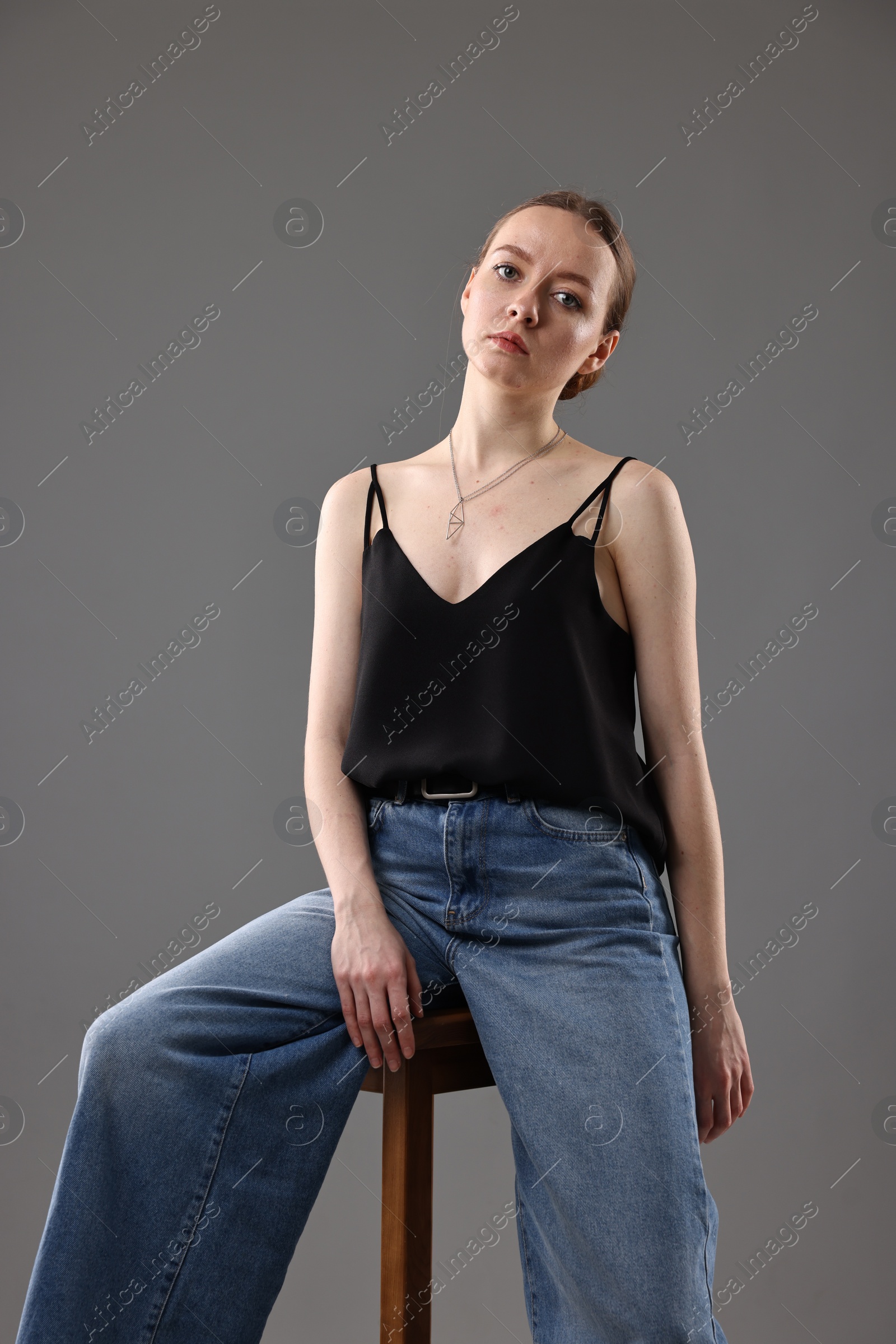 Photo of Fashionable portrait of beautiful young woman on grey background