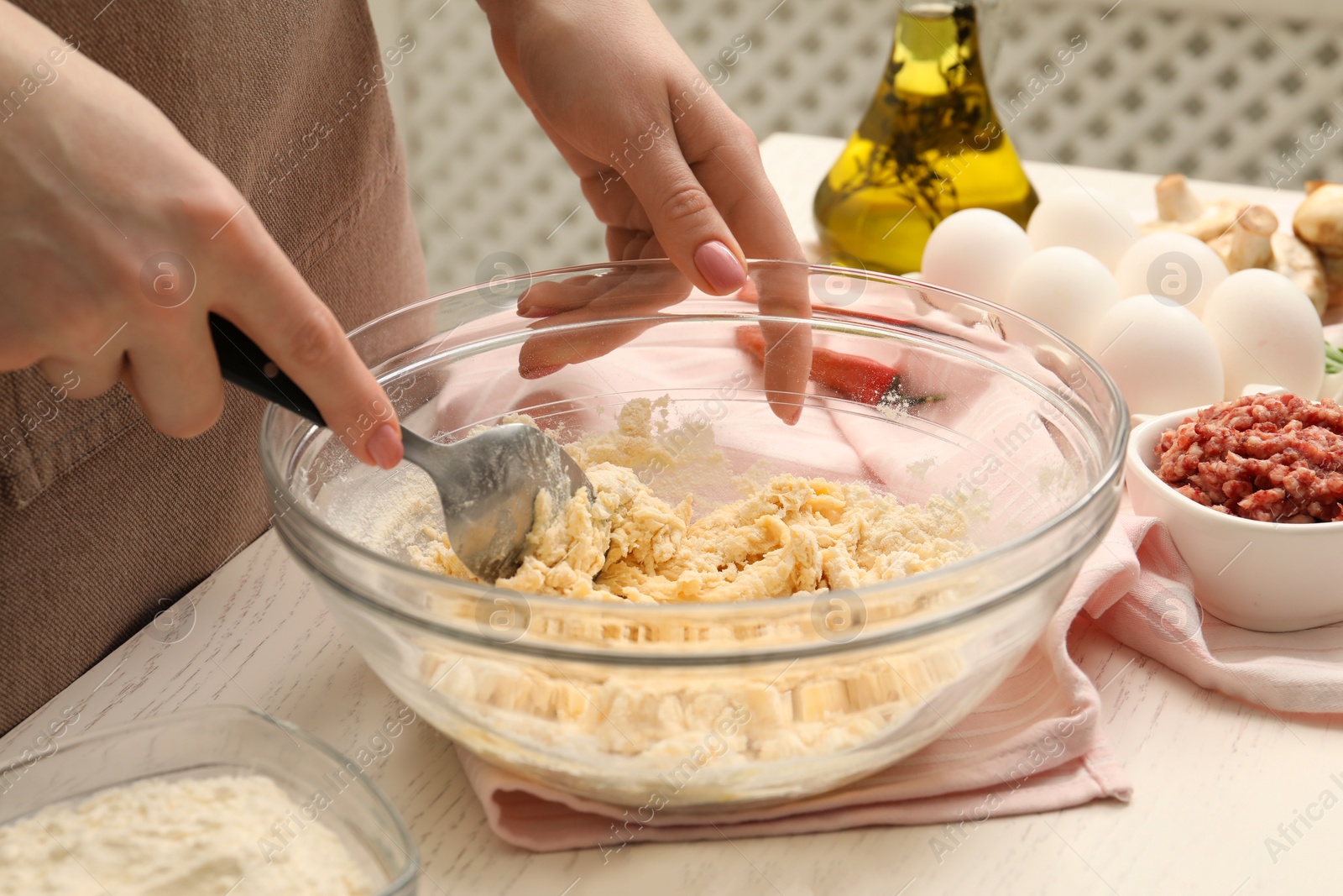 Photo of Woman making dough at white wooden table, closeup