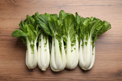 Photo of Fresh green pak choy cabbages on wooden table, flat lay