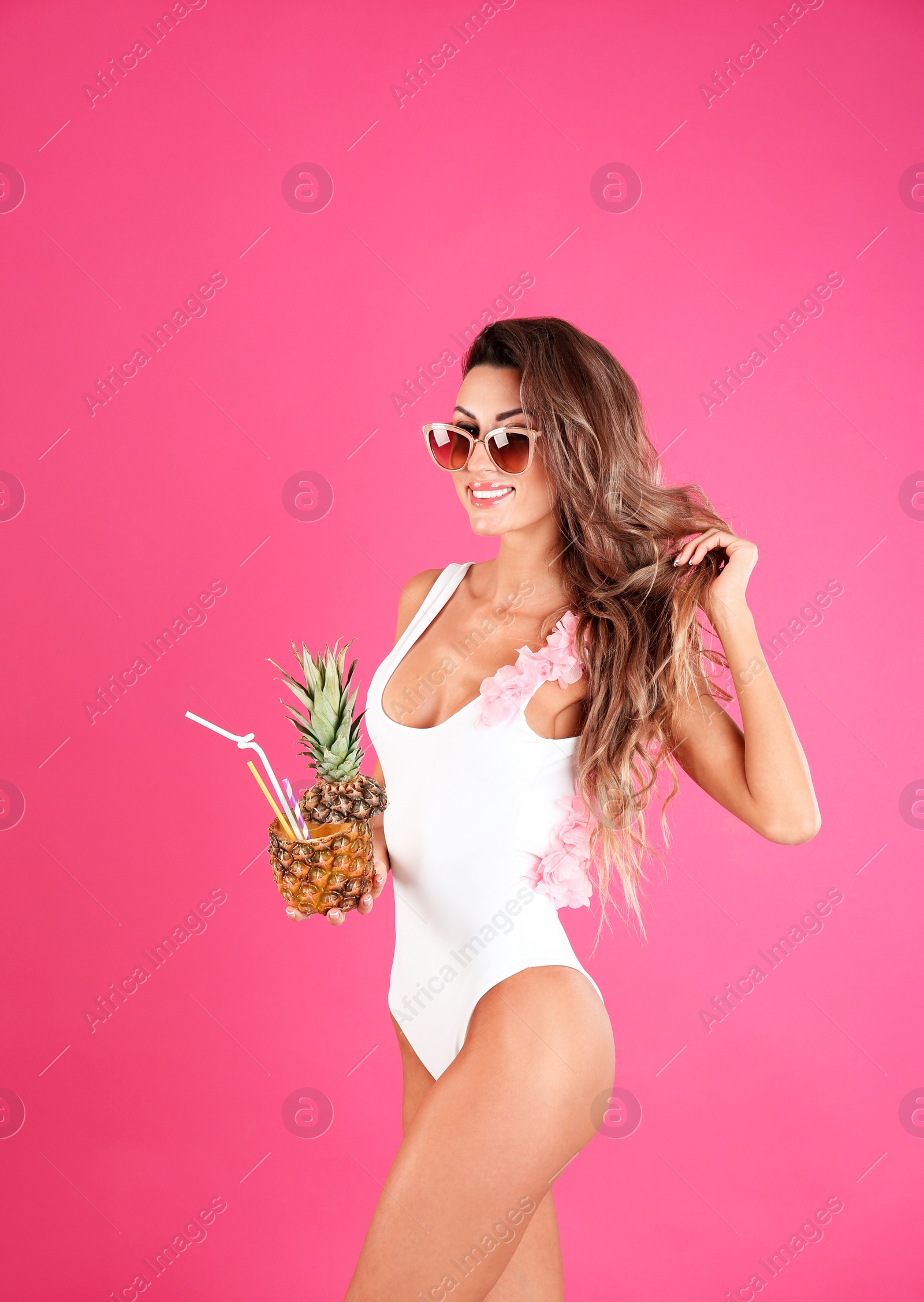 Photo of Pretty sexy woman in stylish bikini with cocktail on color background