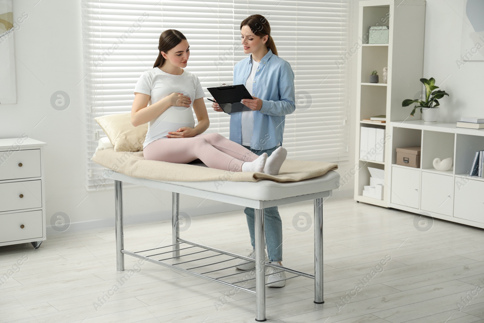 Photo of Doula working with pregnant woman indoors. Preparation for child birth