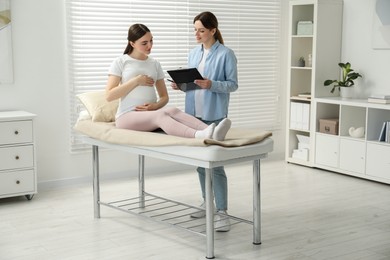 Doula working with pregnant woman indoors. Preparation for child birth