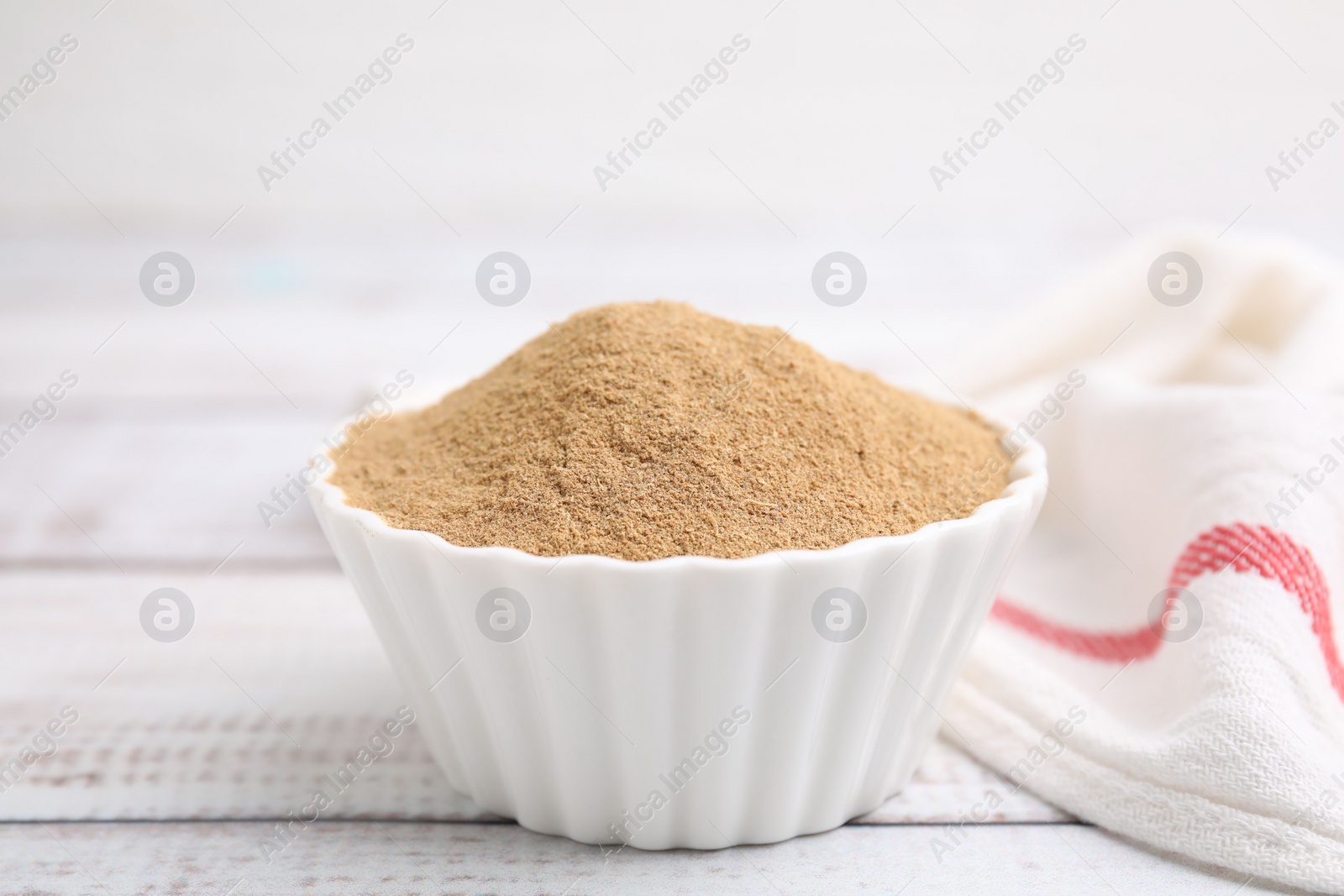 Photo of Dietary fiber. Psyllium husk powder in bowl on wooden table, closeup