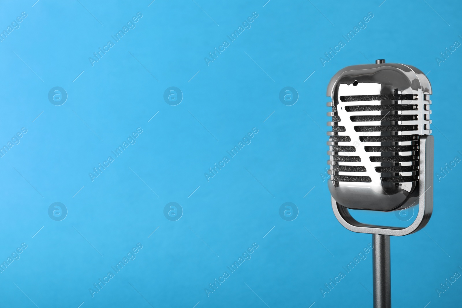 Photo of Retro microphone on color background, space for text