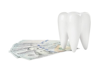 Photo of Ceramic model of tooth and dollar banknotes on white background. Expensive treatment