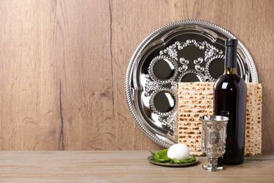 Photo of Symbolic Pesach (Passover Seder) items on wooden table, space for text