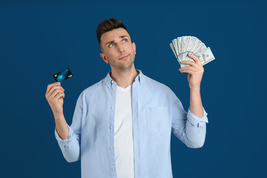 Photo of Man with cash money and credit card on blue background