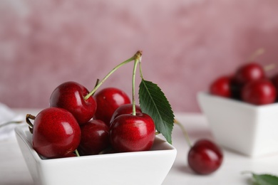 Photo of Bowl with ripe sweet cherries on table, closeup. Space for text