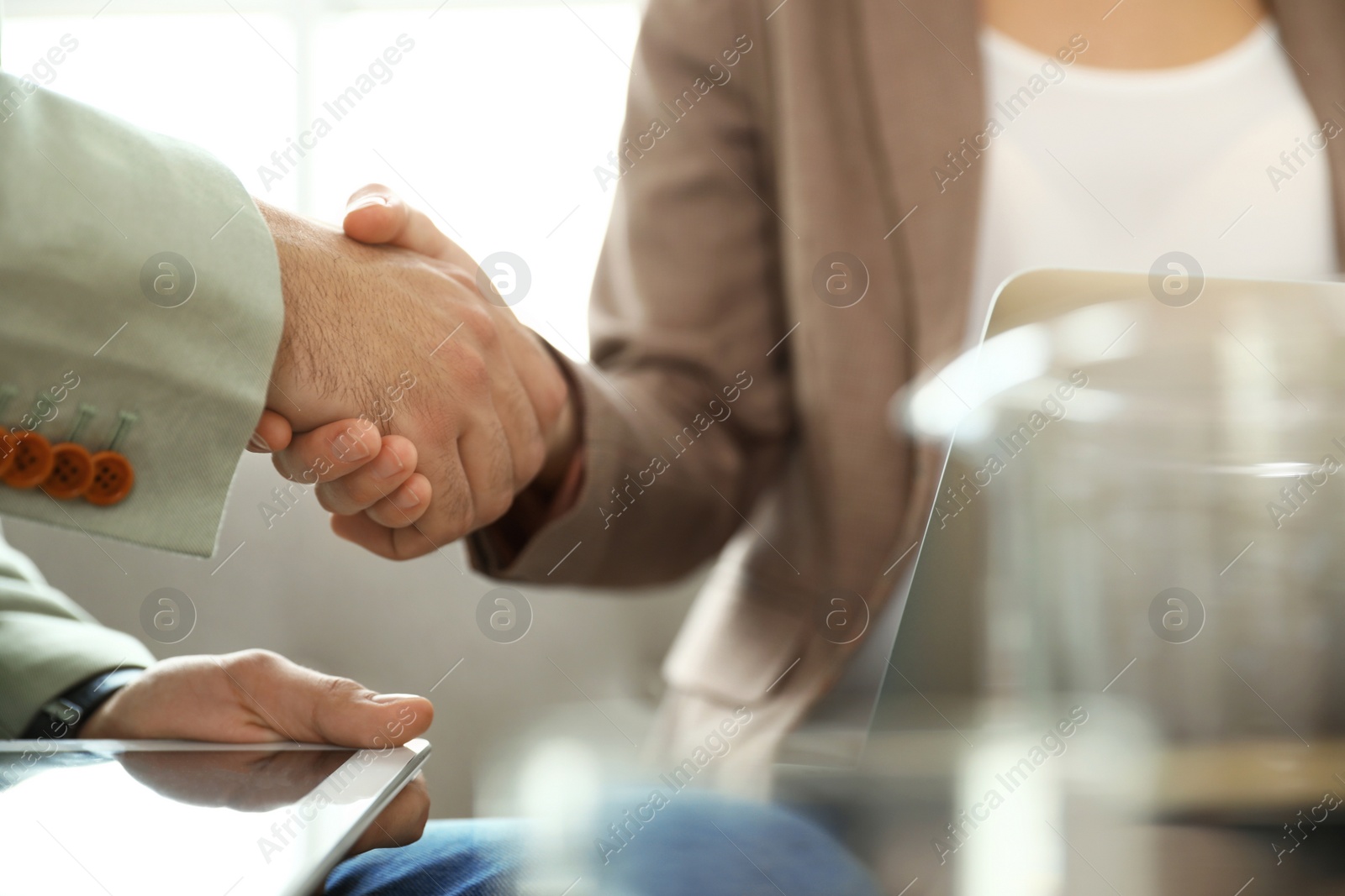 Photo of Business partners shaking hands after meeting, closeup