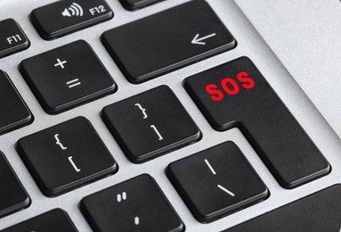 Image of Button with word SOS on computer keyboard, closeup. Rescue concept
