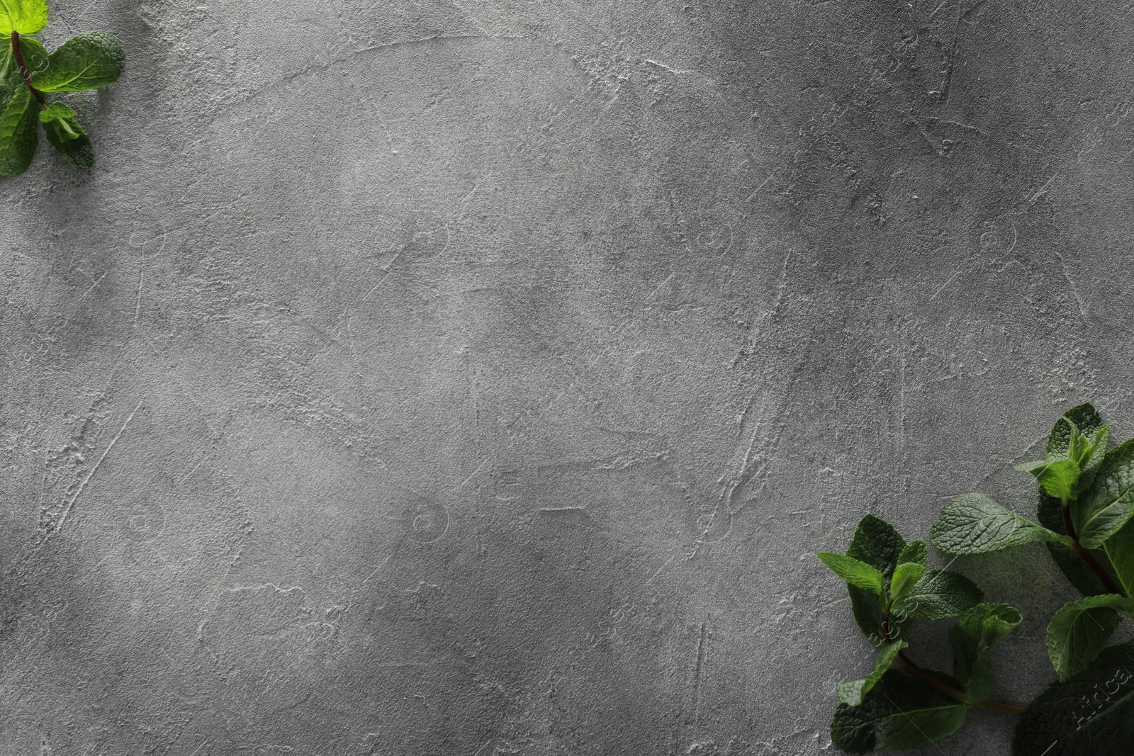 Photo of Food photography. Fresh aromatic mint leaves on grey textured table, flat lay with space for text